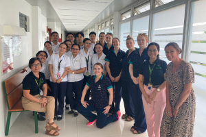 Group of students and hospital staff standing in hospital hallway